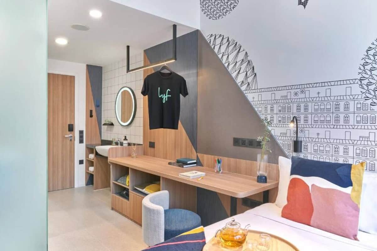 Una cocina moderna con encimera de madera, una camisa colgada y un mural en la pared.