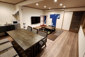 A modern kitchen with a microwave, a dining area with a wooden table and chairs, and a TV mounted on the wall. - [Mina's SamuraiHouse] 1 house (4 bedrooms/9 beds/1 parking lot) (Takayama)