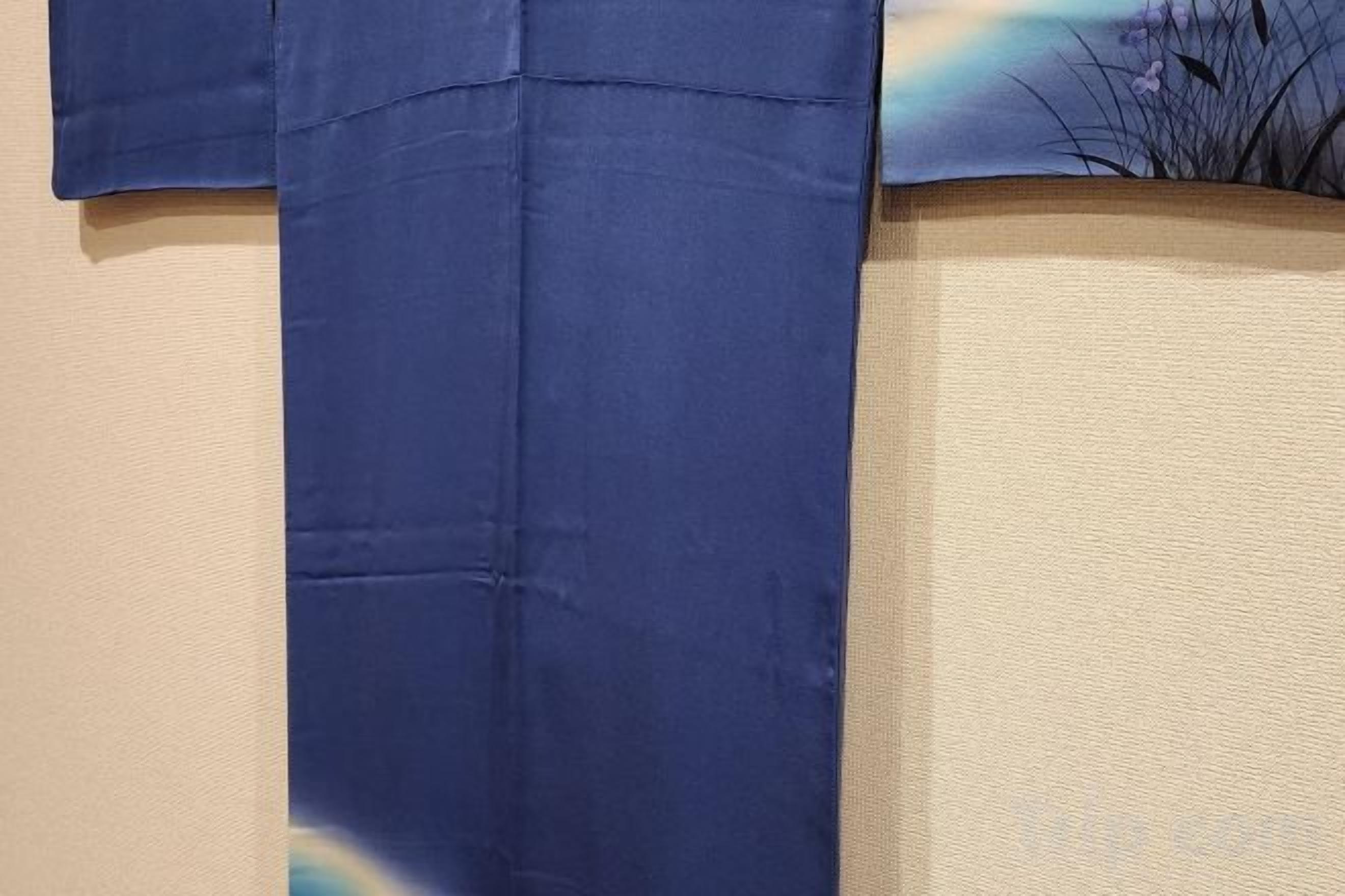 A blue fabric draped over a textured wall.
