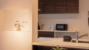 A modern kitchen with a microwave, sink, and cabinets. - New open ! TabiTaimu・Momodani MOMO｜Near Tennoji Park & Shinsekai｜Direct Train to Osaka Castle (Osaka)