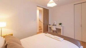 A hotel room with a bed, a desk with a chair, a mirror, and a small plant. - New open ! TabiTaimu・Momodani MOMO｜Near Tennoji Park & Shinsekai｜Direct Train to Osaka Castle (Osaka)