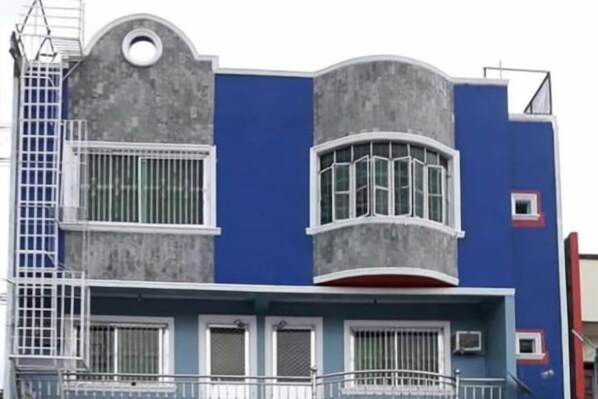 A building with a curved facade, multiple windows, and a balcony.