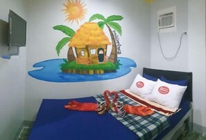 Une chambre avec un lit, une fresque murale représentant un paysage tropical et un téléviseur fixé au mur.