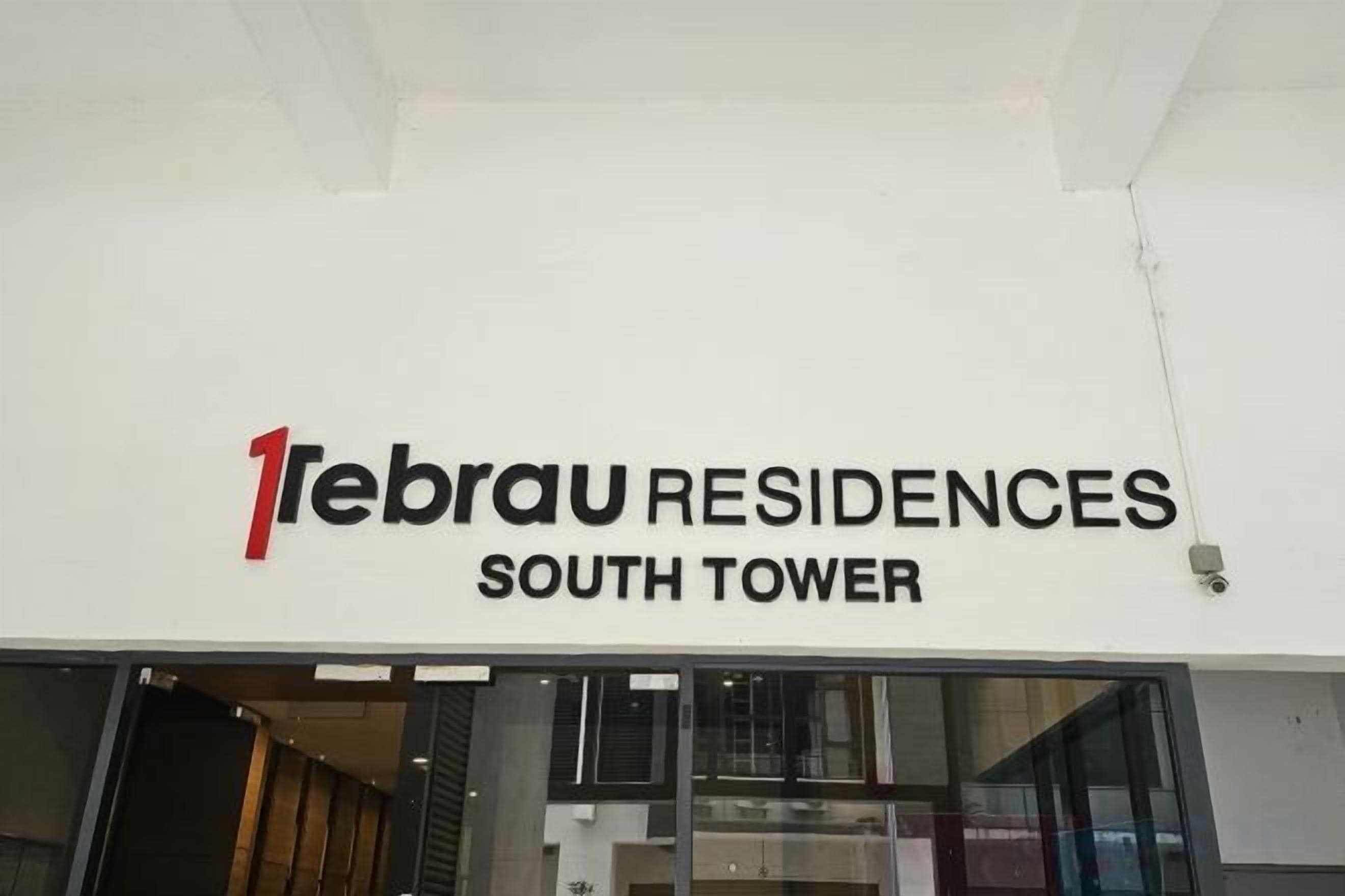 El exterior de la Torre Sur de 1ebrau Residences con un letrero llamativo.