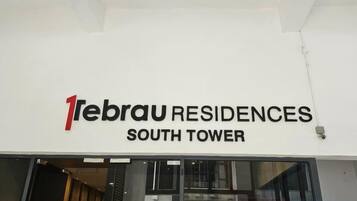 El exterior de la Torre Sur de 1ebrau Residences con un letrero llamativo.