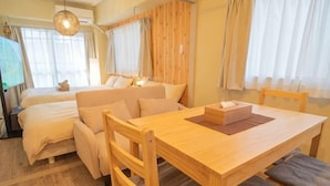Una camera da letto con un letto, un comodino e un tavolo di legno con sedie.