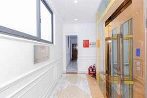 A corridor with a fire extinguisher, a sign, and an elevator. - Phu Gia Hotel 2160 Huynh Tan Phat (Ho Chi Minh City)