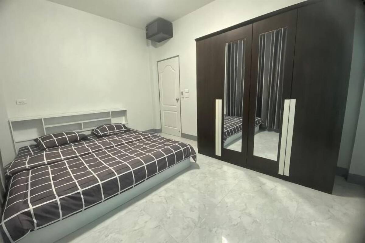 Ein Schlafzimmer mit einem Bett, einem Kleiderschrank und einer Tür.