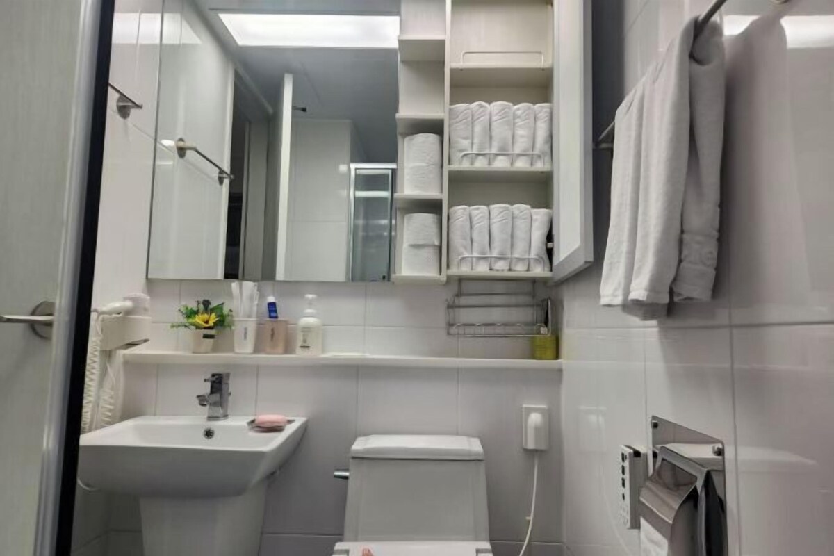 A bathroom with a sink, toilet, towel rack, and a mirror.