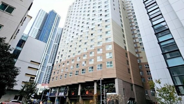 A high-rise building with multiple floors, large windows, and a modern architectural design. - Haeundae Bada Stay (Busan)