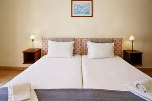A double bed with two pillows, a nightstand with a lamp, and a framed picture on the wall. - Cheerfulway Ouravista Apartamentos (Albufeira)
