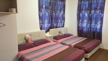 A hotel room with two beds, each with striped bedding, a small nightstand, a teddy bear, and a Hello Kitty plush toy.