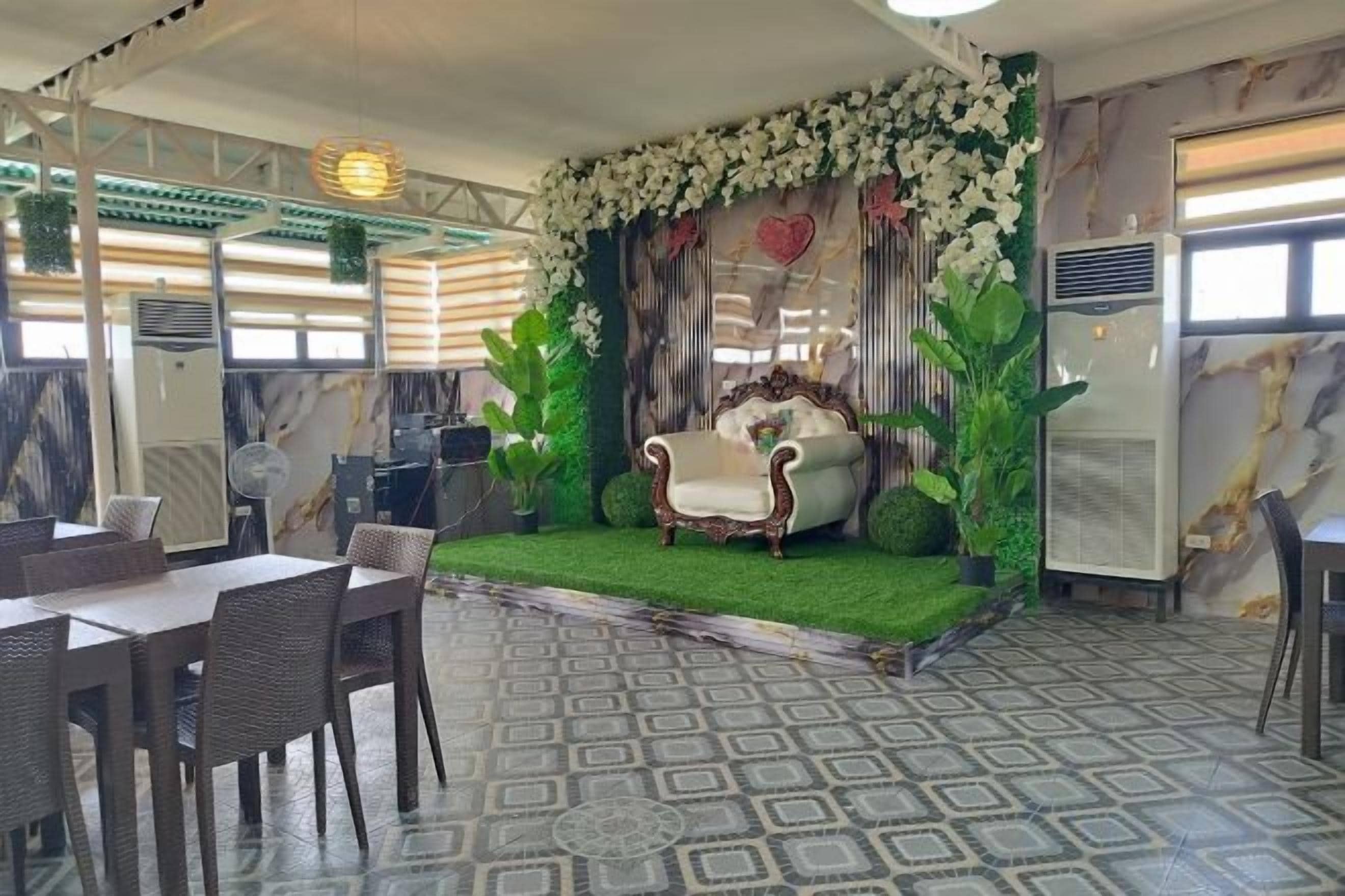 A dining area with a stage, chairs, and a patterned floor.