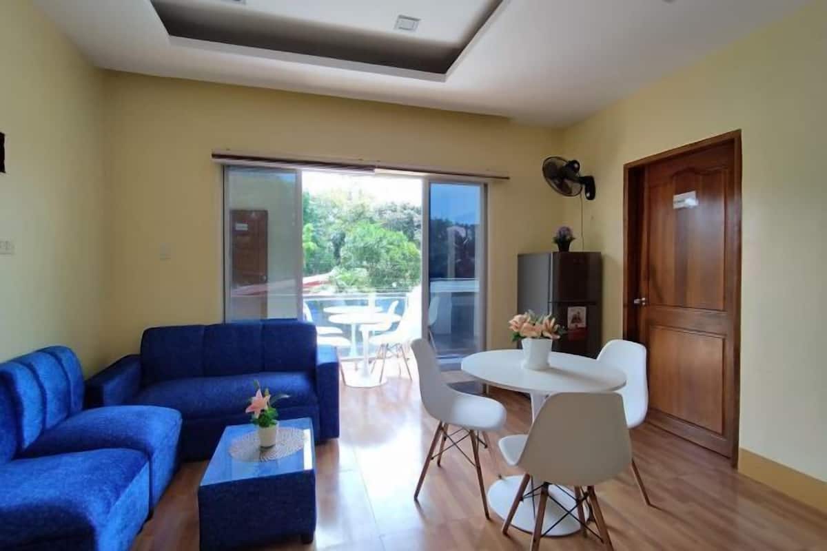 Una sala de estar con sofá, mesa de centro y un comedor con sillas y una mesa.