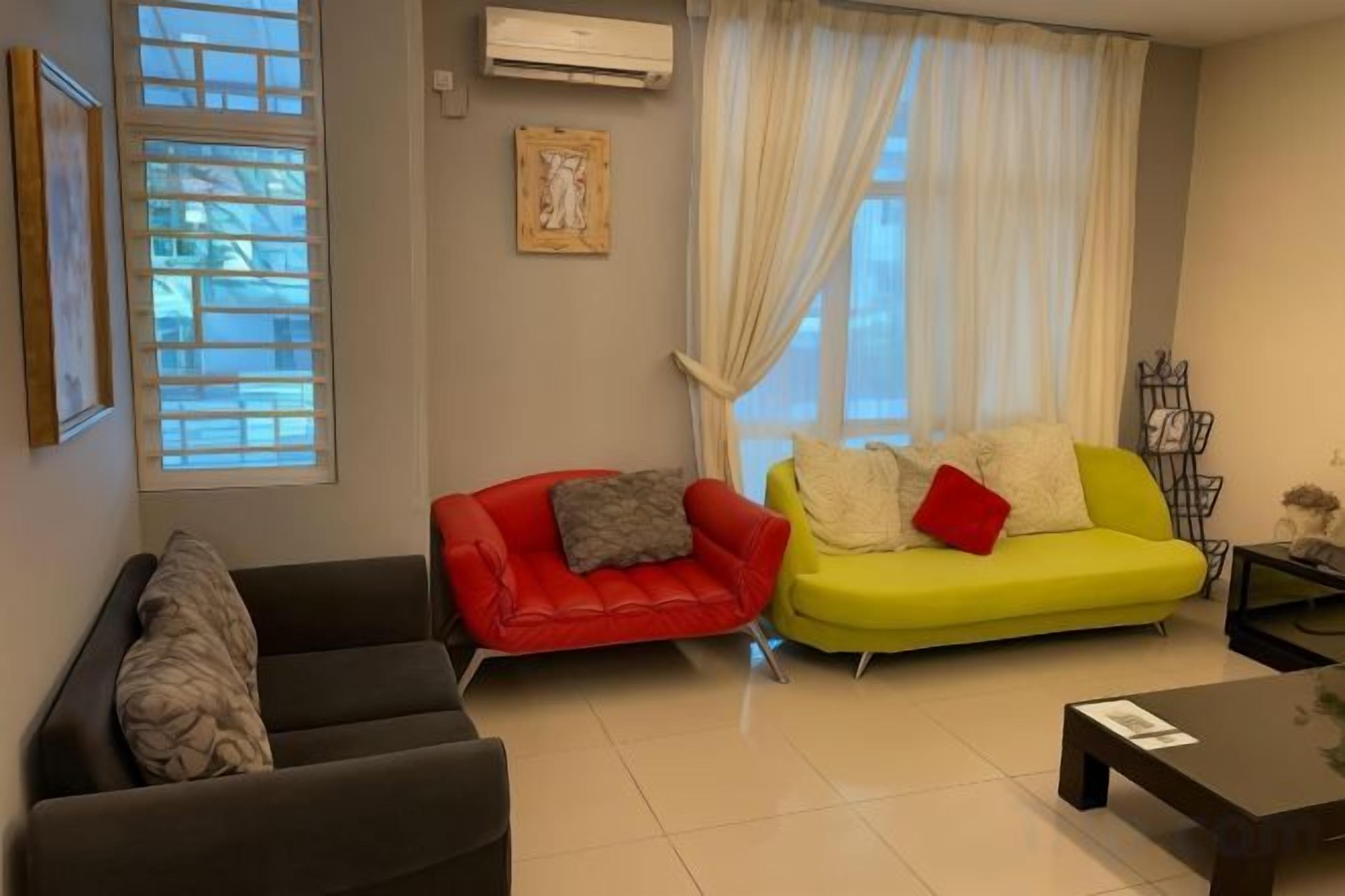 A living room with two sofas, a coffee table, and a window with blinds.