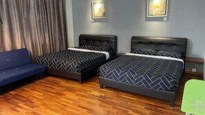 Ein Hotelzimmer mit zwei Betten, einem Schlafsofa und einem grünen Sessel.