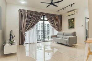 Una sala de estar moderna con un sofá, un ventilador de techo y un ventanal con cortinas.