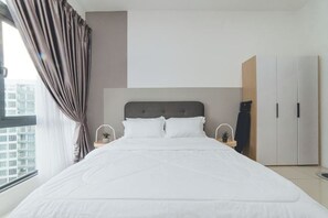 A modern bedroom with a large bed, a headboard, a nightstand with a lamp, a small plant, and a wardrobe. - Perling 8scape 3BR Comfy Zone nr Bukitindah/Sutera (Johor Bahru)