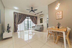 A spacious living area with a dining table, a sofa, and a ceiling fan. - Perling 8scape 3BR Comfy Zone nr Bukitindah/Sutera (Johor Bahru)