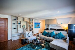 A modern living room with a sofa, coffee table, and built-in shelving. - Villa ZeniMo, Surin Beach, pool, 9 BR 18 guests (Phuket)