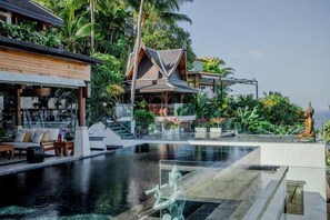 A resort with a infinity pool, a statue, and traditional architecture. - Villa ZeniMo, Surin Beach, pool, 9 BR 18 guests (Phuket)
