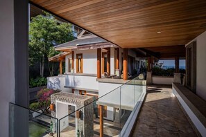 A modern house with a balcony, a pool, and a view of the surrounding greenery. - Villa ZeniMo, Surin Beach, pool, 9 BR 18 guests (Phuket)