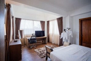 A hotel room with a bed, desk, TV, and a wardrobe with hanging clothes. - Villa ZeniMo, Surin Beach, pool, 9 BR 18 guests (Phuket)