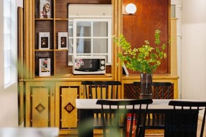 Cocina compacta con microondas, ventana y planta en maceta.