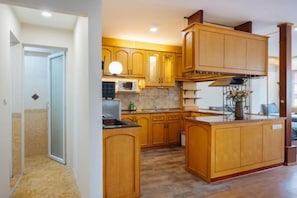 Una cocina con armarios de madera, un microondas y un lavamanos.