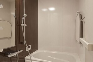 A modern bathroom with a bathtub, a shower, and a toilet.
