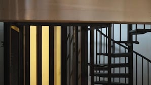 A staircase with a metal railing and a beige ceiling.
