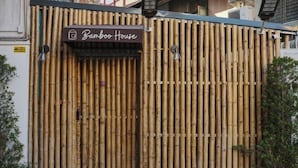 A bamboo wall with a sign reading "Bamboo House".