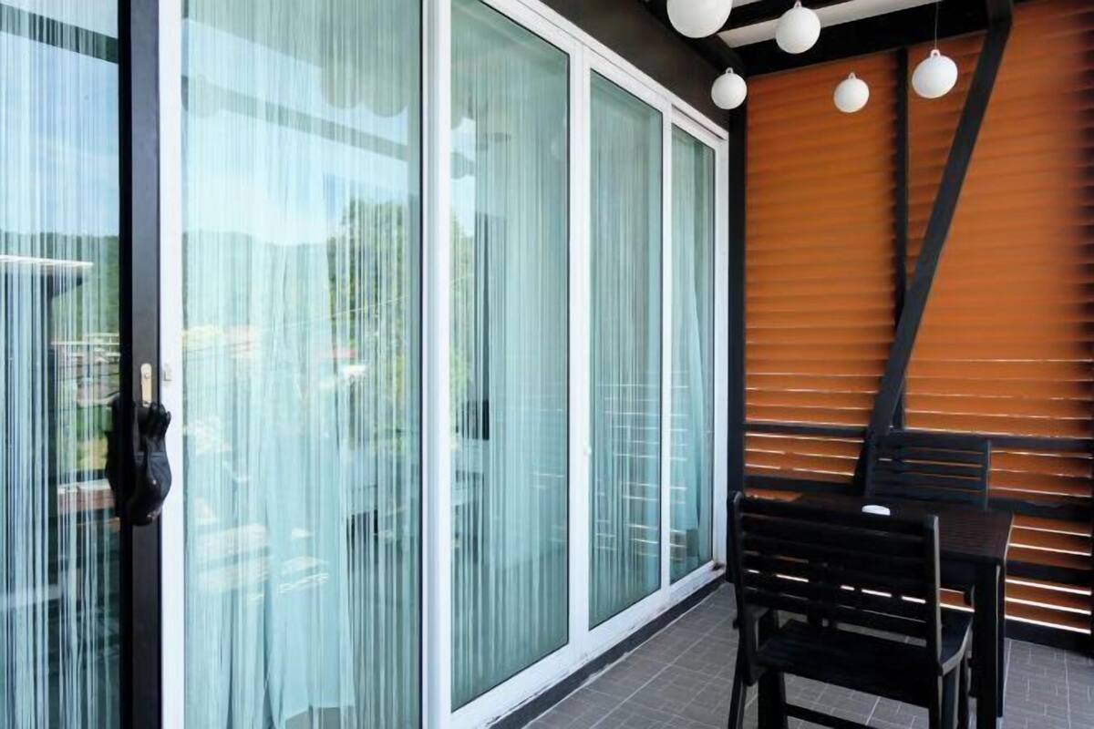 A modern interior with large glass doors, a wooden slatted wall, and a table with chairs.