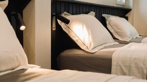 A bedroom with two beds, each with white bedding and pillows, and a wall-mounted light fixture. - My Sukhumvit Villa (Bangkok)