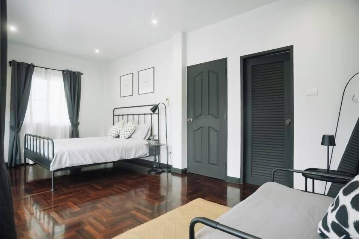 A bedroom with a bed, a bedside table, a chair, and a wardrobe.