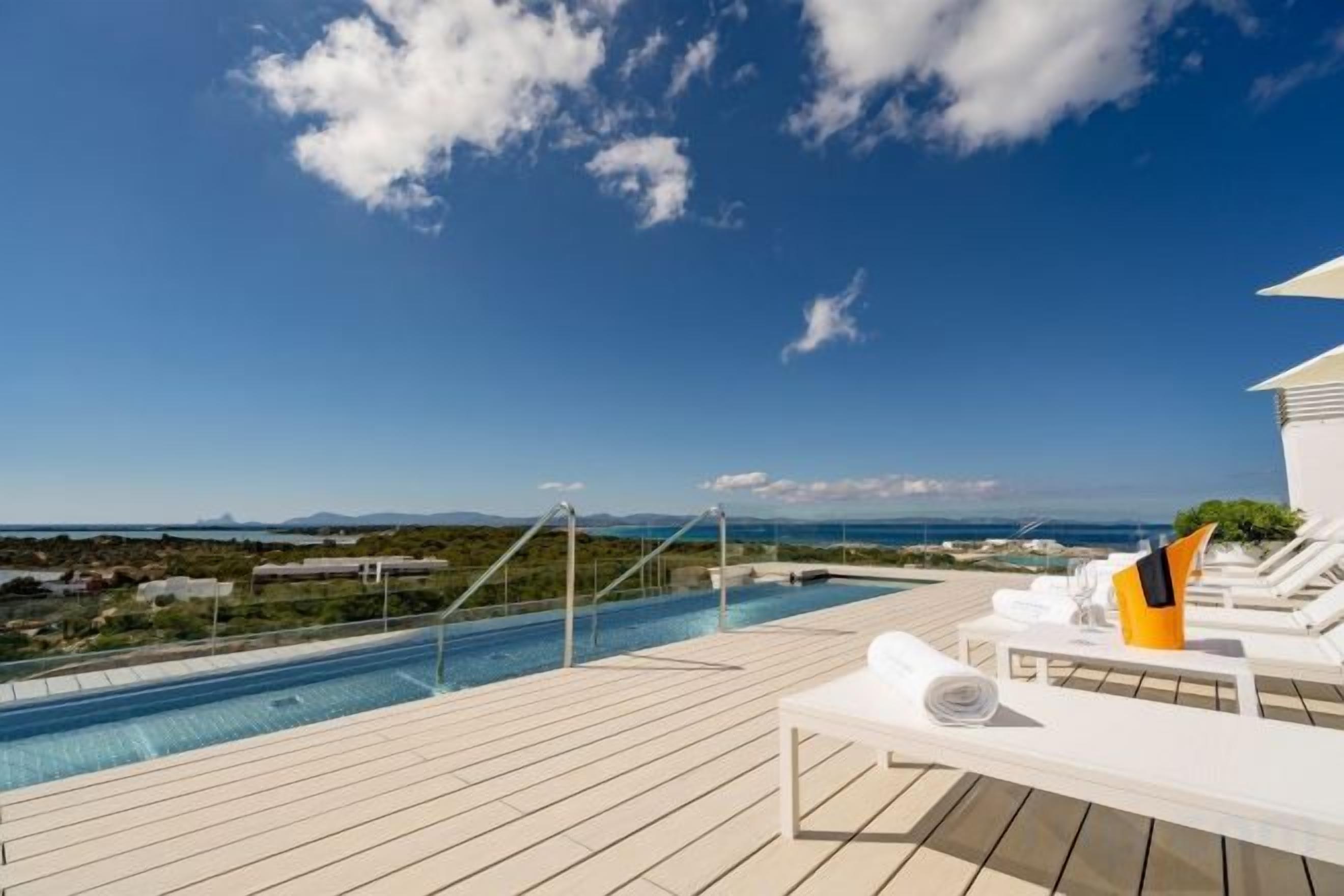 Ein Poolbereich mit Liegestühlen und Blick auf die Landschaft.