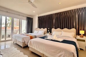 A hotel room with two beds, a balcony, and a view of the outside. - Chasing Light Villa (Pattaya)