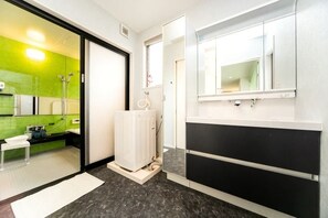 Un baño moderno con ducha, inodoro, lavabo y espejo.