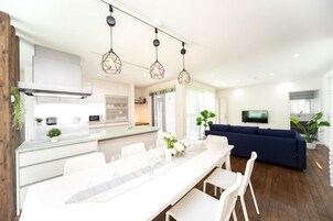Una cocina moderna con comedor, un sofá y una televisión en la sala.