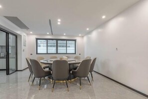 A conference room with a round table, chairs, and a large window.
