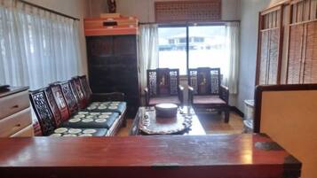 Een klassieke kamer met een houten tafel, bank en stoelen.