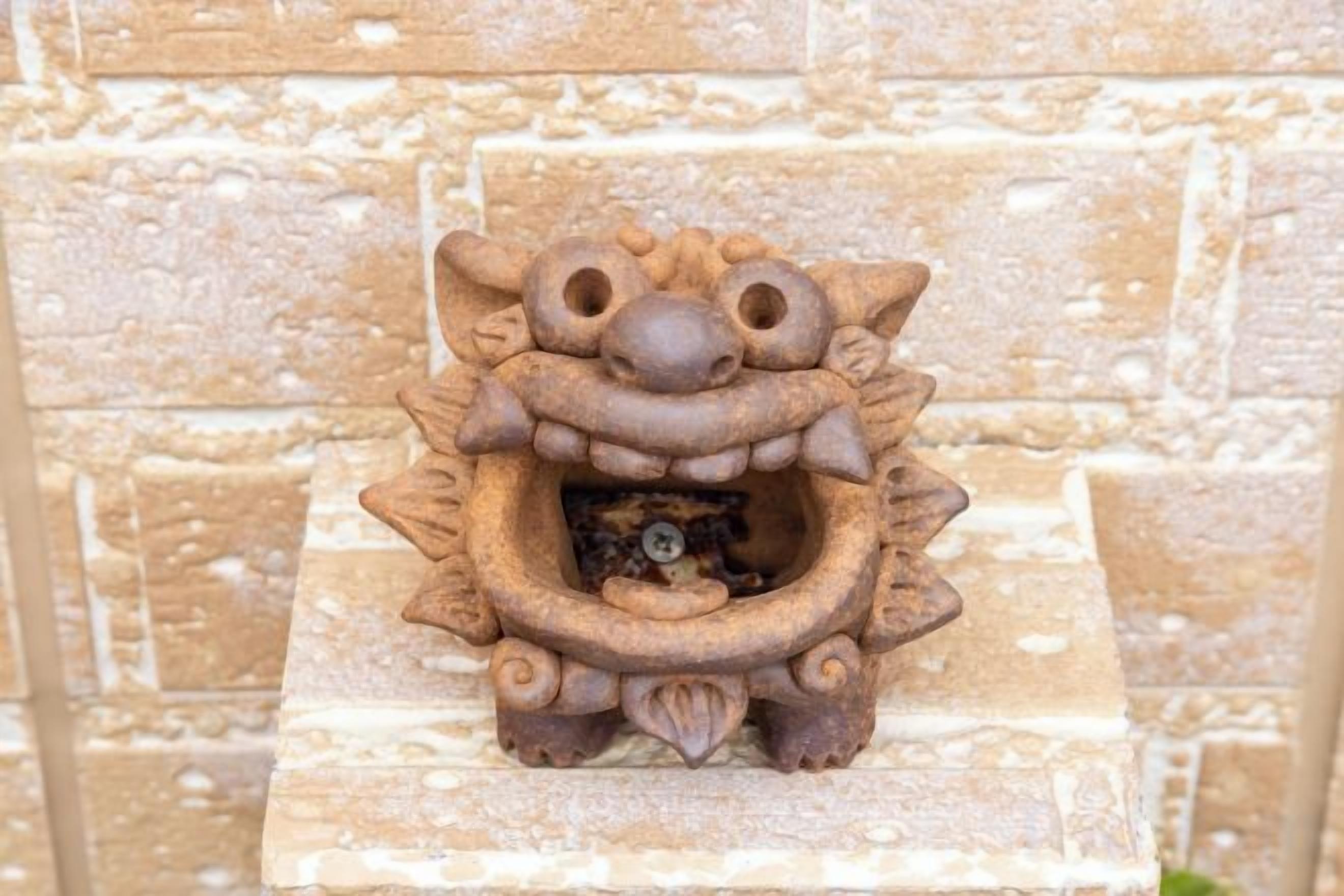 A stone lion statue mounted on a wall.