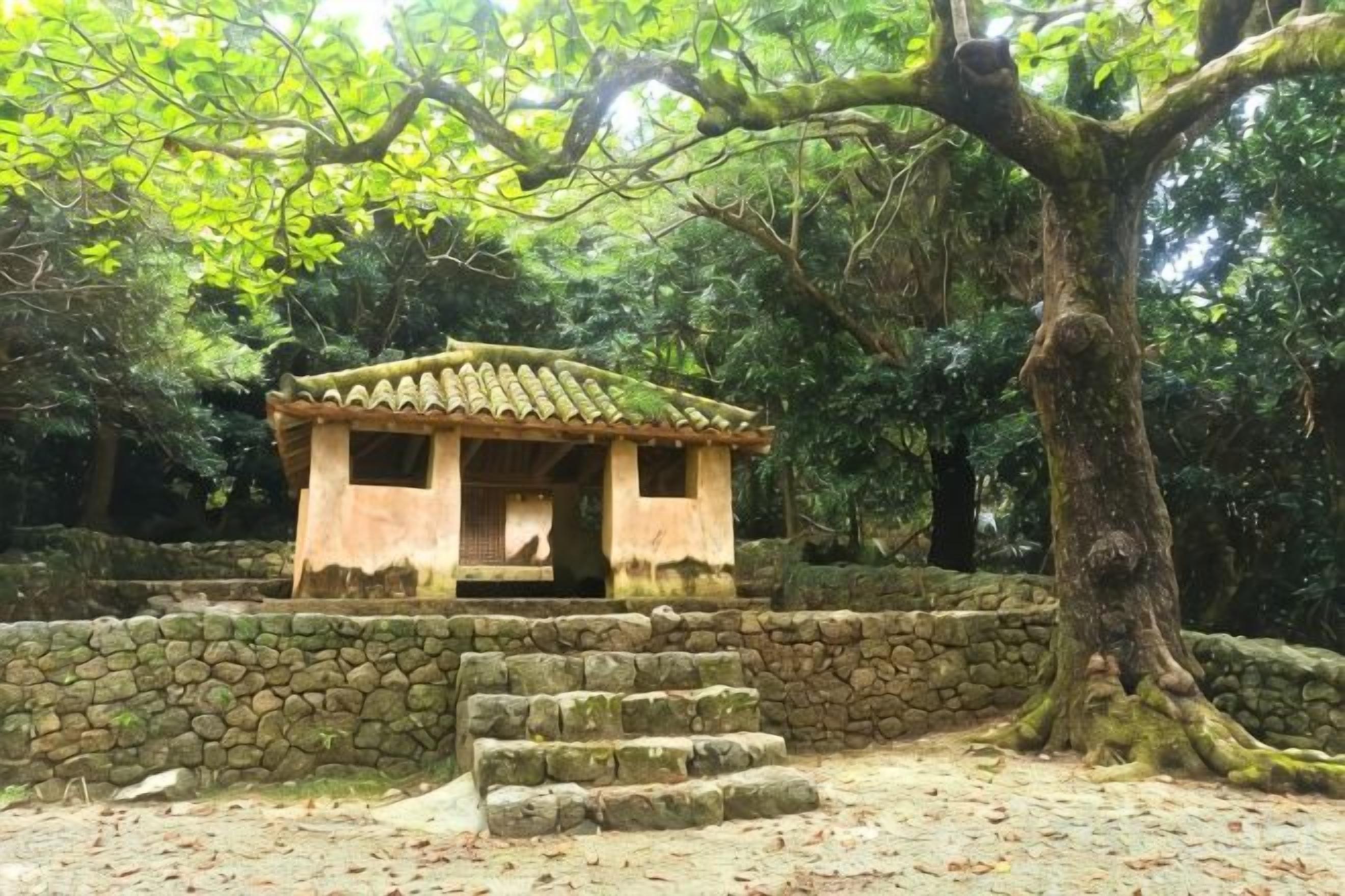 A traditional Japanese-style building with a tiled roof, surrounded by a stone wall and a large tree.