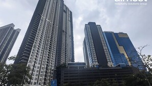 Ein Hochhaus mit modernem architektonischen Design, das durch eine markante vertikale Struktur und eine Kombination aus Glas- und Betonfassaden gekennzeichnet ist.