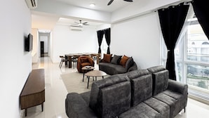 Ein modernes Wohnzimmer mit einer Couch, Sesseln, einem Couchtisch und einem Essbereich mit Stühlen und einem Tisch.