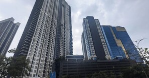 Un edificio de gran altura con un diseño arquitectónico moderno, que presenta una estructura vertical destacada y una combinación de fachadas de vidrio y concreto.