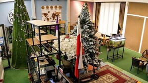 A room with a Christmas tree, a desk with a computer, and a bookshelf. - Chill Out (Vy Da)