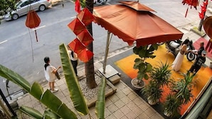 A street view with a restaurant patio, a motorcycle, and a pedestrian. - Chill Out (Vy Da)