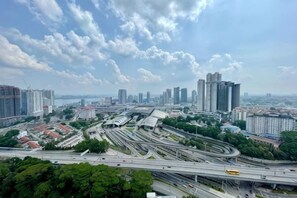 A cityscape with high-rise buildings, a complex highway interchange, and a clear sky. - Paragon Suites L18 By UCome Homestay (Johor Bahru)