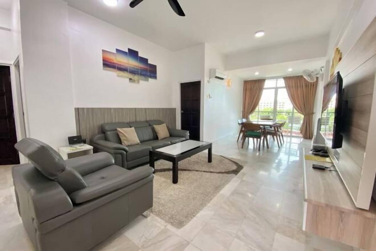 A modern living room with a sofa, coffee table, and a dining area with a table and chairs.